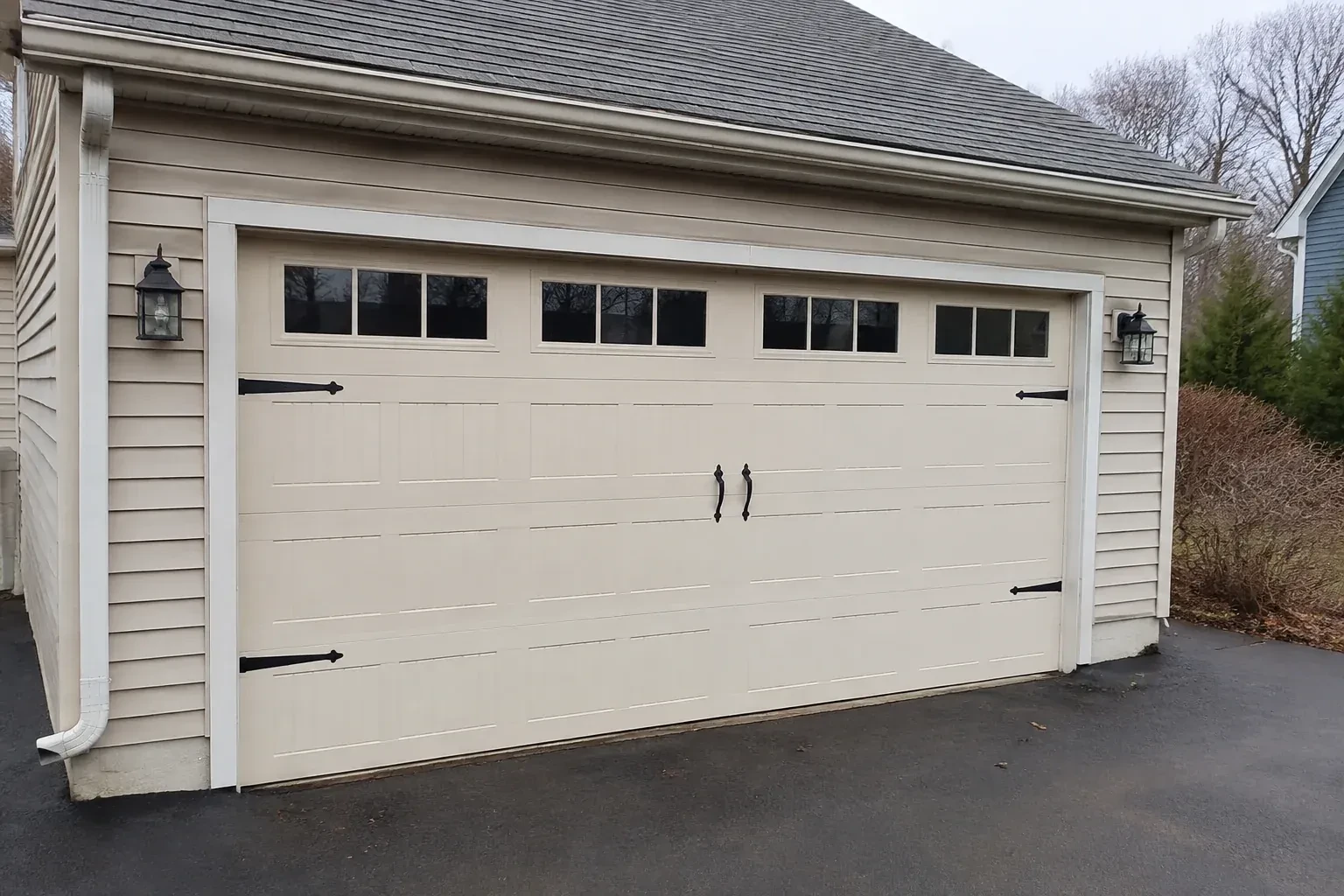 Cream carriage-house-style garage door with dark decorative hardware. — Carriage-House Garage Door Installation, Guelph