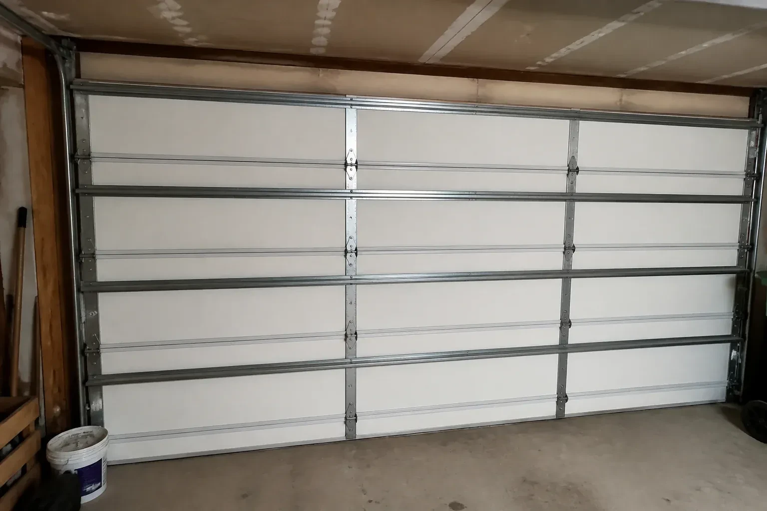 Interior of a closed sectional door with horizontal metal reinforcement struts. — Wind-Rated Garage Door Replacement, Guelph